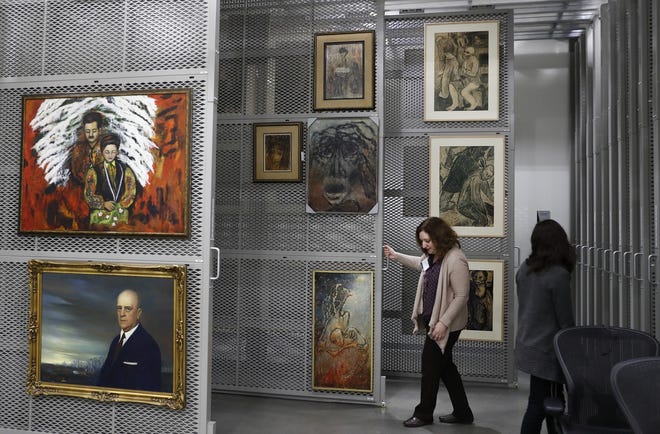Laura Seylar, registrar of Collections Management, slides open a section of the art rack at the U.S. Holocaust Memorial Museum's David and Fela Shapell Family Collections, Conservation and Research Center in Bowie, Md., on Monday. [Carolyn Kaster / AP]