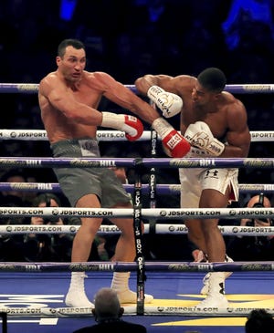 British boxer Anthony Joshua, left, in action against Ukrainian boxer Wladimir Klitschko for Joshua's IBF and the vacant WBA Super World and IBO heavyweight titles, at Wembley Stadium, in London, Saturday, April 29, 2017. (Peter Byrne/PA via AP)