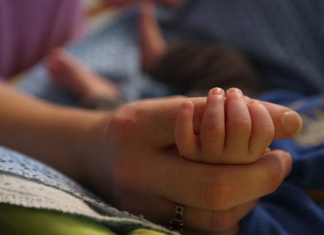 A woman holds her baby’s hand at CARE Inc.’s women’s residential treatment program in Panama City. [PATTI BLAKE/NEWS HERALD FILE PHOTO]