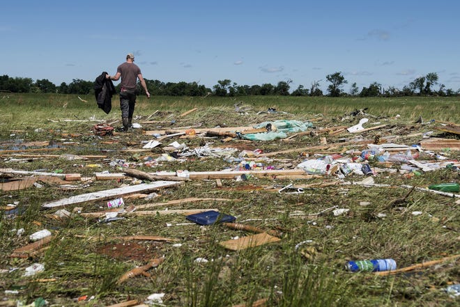 Kyle Allen walks his parents' property in Canton, Texas on Sunday, April 30, 2017, looking for personal items. Severe storms including tornadoes swept through several small towns in East Texas, killing several people, and leaving a trail of overturned vehicles, mangled trees and damaged homes, authorities said Sunday. (Sarah A. Miller/Tyler Morning Telegraph via AP)
