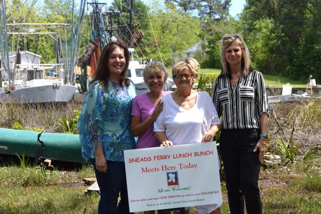 Ruth Anne Bland, holding sign, has created Sneads Ferry Lunch Bunch as a way for local women to get out of the house. With Blind are, from left, Lilla Keresztury, her daughter Caryn Roskiewich, and Tracy Iovanna. [Alan Lane/The Daily News]