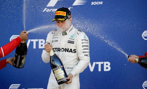 Mercedes driver Valtteri Bottas of Finland is sprayed with champagne as he celebrates his victory at the Formula One Russian Grand Prix at the 'Sochi Autodrom' circuit, in Sochi, Russia, Sunday, April. 30, 2017. (AP Photo/Pavel Golovkin)