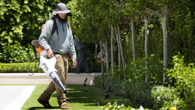 A landscape worker uses an electric leaf blower. Daily News File Photo