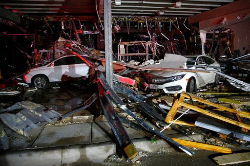 Cars and trucks are damaged as the walls blew out of the I-20 Dodge dealership after a tornado hit near Canton, Texas, Saturday. The National Weather Service says at least one tornado hit Canton, while tornadoes also were reported in surrounding areas.