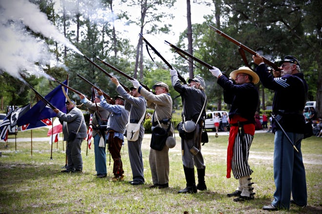 Soldiers fire off their guns during a memorial for nine Civil War veterans, eight who fought for the Confederate side and one for the Union, buried at High Springs Cemetery on Saturday. The ceremony, which was held by the Historical Society and by the Sons of Confederate Veterans with representatives from the John Hance O´Steen, Gen. Eugene A. Carr and the Dixie Defenders camps, concluded the memorial with cannon fire and a 21-gun salute. [Andrea Cornejo/Staff photographer]
