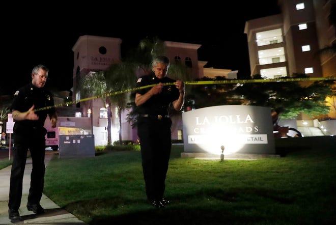 San Diego police officers work at a cordoned off La Jolla apartment after a shooting Sunday, April 30, 2017, in San Diego. Police shot and killed a 49-year-old man suspected of shooting seven people Sunday at a birthday pool party in an apartment complex near the University of California, San Diego, authorities said. (AP Photo/Gregory Bull)