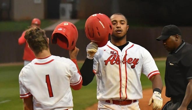 Belmont Abbey's Matt McGarry (1) greets Nick Beinlich after one of his 21 home runs this season. Beinlich was Conference Carolinas player of the year for the league tournament runner-up Crusaders. [BAC ATHLETICS PHOTO]