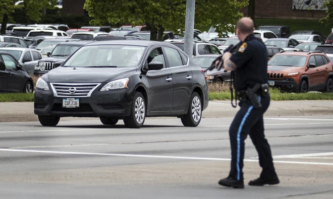 An Omaha police officer points his rifle in the direction of a vehicle headed eastbound on Cuming Street driven by an inmate who escaped from the Pottawattamie County jail in Council Bluffs, Iowa, and carjacked a Nissan Sentra, Monday, May 1, 2017, in Omaha, Neb. The inmate was captured after crashing the stolen vehicle during a police chase in neighboring Nebraska. THE WORLD-HERALD/AP