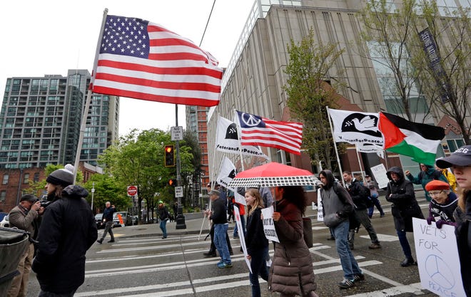 An American flag is carried to lead a small anti-war march by veterans during a May Day demonstration Monday, May 1, 2017, in Seattle. THE ASSOCIATED PRESS