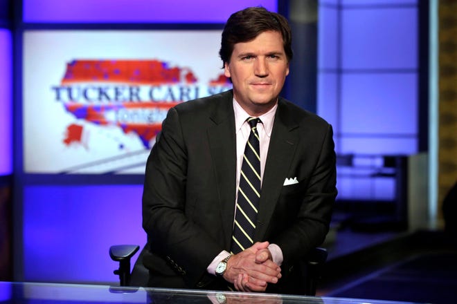In this March 2, 2017 file photo, Tucker Carlson, host of “Tucker Carlson Tonight,” poses for photos in a Fox News Channel studio, in New York. The Fox News host and longtime conservative commentator has a two-book deal with Threshold Editions, the publisher said Tuesday, May 2. Carlson also authored, “Politicians, Partisans, and Parasites: My Adventures in Cable News,” which came out in 2003. (AP Photo/Richard Drew, File)