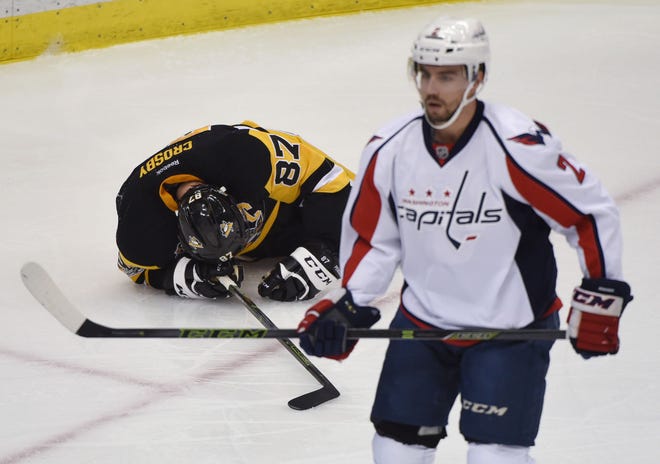 Penguins captain Sidney Crosby lays on the ground after being cross-checked by the Capitals' Matt Niskanen (2) during the first period of Game 3 in the second round of the Stanley Cup Playoffs on Monday at PPG Paints Arena in Pittsburgh.