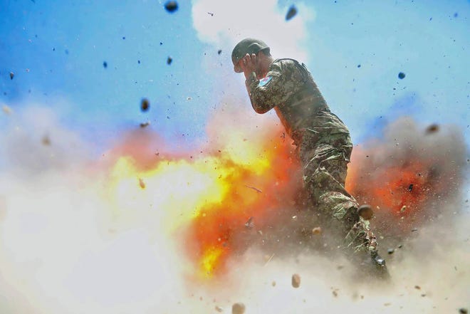 U.S Army combat camera photographer Spc. Hilda Clayton took this photo July 2, 2013 that was released by the U.S. Army, that shows an Afghan soldier engulfed in flame as a mortar tube explodes during an Afghan National Army live-fire training exercise in Laghman Province, Afghanistan. The accident killed Clayton and four Afghan National Army soldiers. (Spc. Hilda Clayton/U.S. Army via AP)