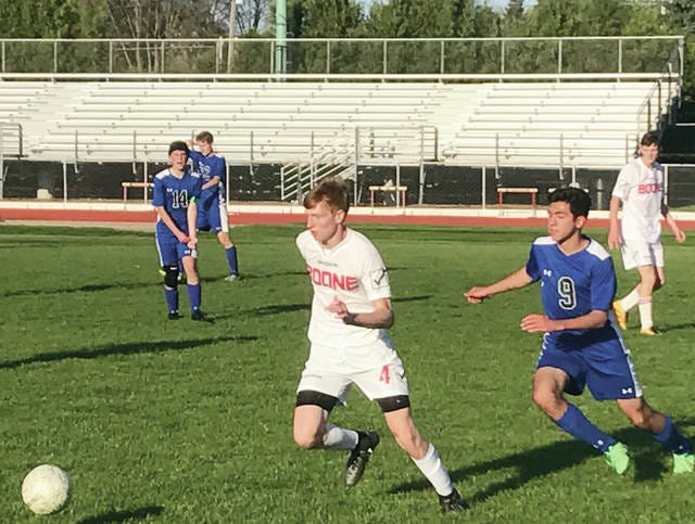 Boone’s Brent Gustafson, center, tries to keep the ball away from an Ankeny Christian Academy opponent in his team’s 2-1 victory Tuesday. Boone has surpassed its win total from last season with four matches remaining this spring. Up next is a Thursday trip to Webster City. (Luke Manderfeld/Special to the News-Republican)