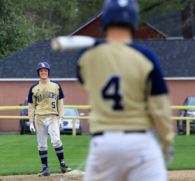 Traip's Shane MacNeill smiles from third base as Trevor Salema goes up to bat during Wednesday's Class C South baseball game against Waynflete. Traip won 10-0 in six innings.