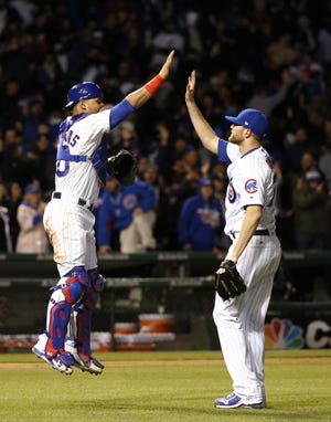 Chicago Cubs catcher Willson Contreras, left, and relief pitcher Wade Davis celebrate the Cubs' 5-4 win over the Philadelphia Phillies in a baseball game Wednesday, May 3, 2017, in Chicago. [CHARLES REX ARBOGAST/THE ASSOCIATED PRESS]