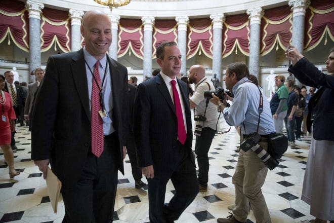 White House Chief of Staff Reince Priebus, center, accompanied with congressmen, walks towards the House Chamber on Capitol Hill in Washington, Thursday, May 4, 2017. The Republican health care bill, a top-flight priority the party nearly left for dead six weeks ago, passed a House showdown vote. (AP Photo/Andrew Harnik)