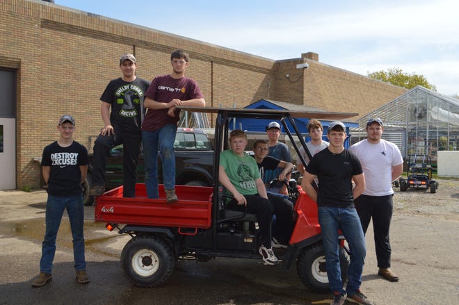 Buckeye Career Center students from the outdoor power equipment technology program recently helped with repairs to one of the Carroll County Historical Society’s side-by-side utility task vehicles. Pictured: the students assemble around the UTV. PHOTO PROVIDED