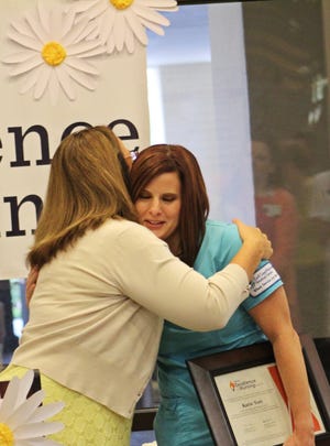 Mary Reval, chief nursing officer at Gulf Coast Regional Medical Center, hugs Katie Yori, right, after announcing she had won the Compassionate Care award during the HCA Excellence in Nursing Awards ceremony Thursday. [ERYN DION/THE NEWS HERALD]