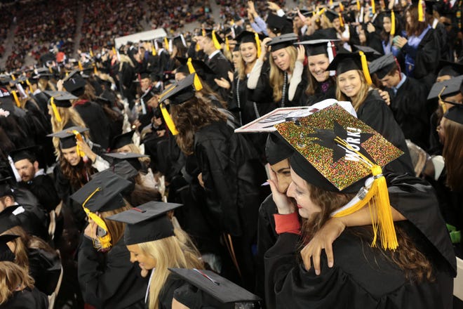 Graduates of the University of Georgia’s Franklin College of Arts and Sciences celebrate and embrace during UGA’s 2017 undergraduate commencement exercises Friday night. (Photo/ John Roark, Athens Banner-Herald)