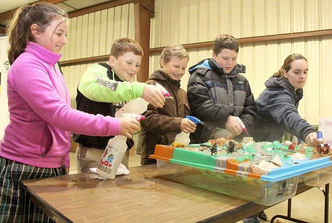 Hillsdale Conservation District Soil Conservation Technician Laura Muntzinger (right) helps students from Will Carleton Academy learn about the water cycle by flooding a water table. Students include Ava Ruley, Will Theilen, Maxx Kies and Tyler Sanders. 

[ANDY BARRAND PHOTO]