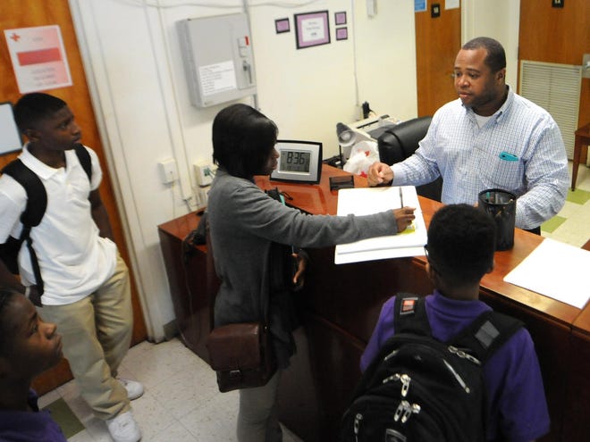 Michael Mitchell welcomes students to Virgo Preparatory Academy on the first day of class in July 2016. Mitchell now runs the front desk at New Hanover County Schools central office. [STARNEWS FILE PHOTO]