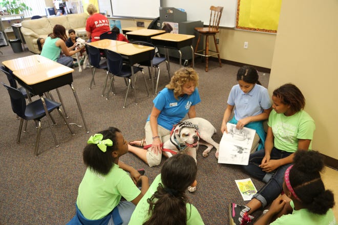 Students at Sawgrass Bay Elementary School in Clermont read to service dog Karl from the South Lake Animal League. A 2010 study by researchers at the University of California-Davis confirmed that children who read to dogs perform better than those who don't. [SUBMITTED]