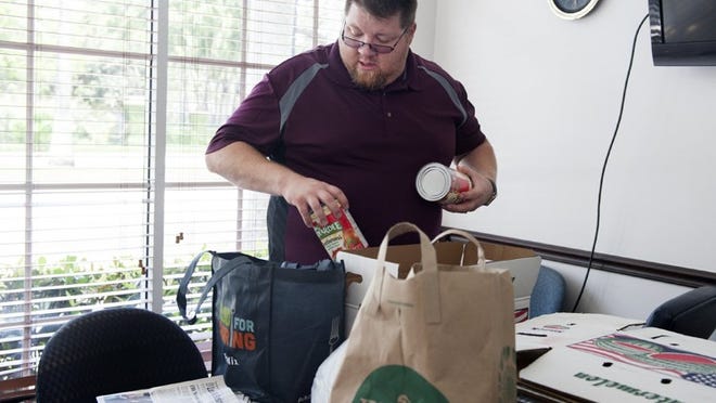 Brian Rowe of Christians Reaching Out to Society (CROS Ministries) collects donated food at the Palm Beach Daily News on May 1. ( Meghan McCarthy / Daily News )