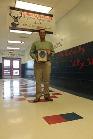 Bozeman band director Brandon Poiroux poses with the band’s award. [SPECIAL TO THE NEWS HERALD]