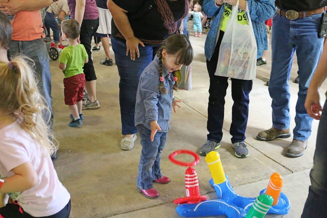 Grace Merical, of Adel, place ring toss at Toddler Fest. Toddler Fest, sponsored by 4RKids, took place at the Dallas County Fairgrounds on May 6. PHOTO BY CLINT COLE/DALLAS COUNTY NEWS