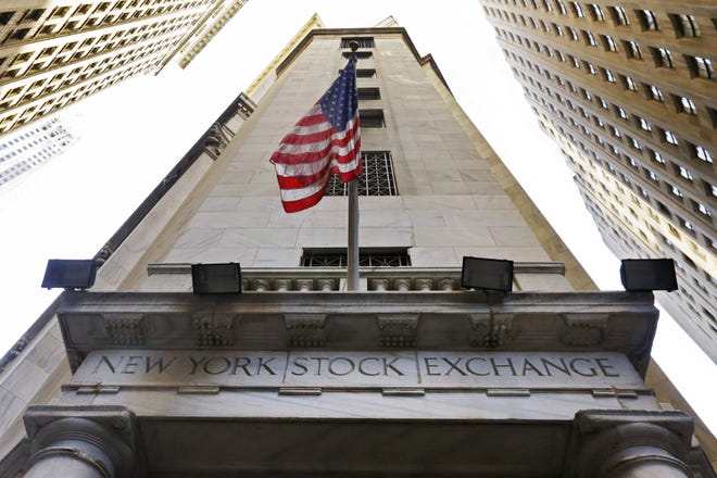 In this Friday, Nov. 13, 2015, file photo, the American flag flies above the Wall Street entrance to the New York Stock Exchange. European stock markets gave up some recent gains Monday, May 8, 2017, after Emmanuel Macron comfortably won the French presidential election. Over the past couple of weeks, European stocks, particularly French ones, had been buoyant on expectations of a Macron victory over the far-right candidate Marine Le Pen. THE ASSOCIATED PRESS