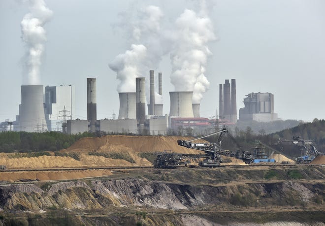 In this April 3, 2014, file photo, giant machines dig for brown coal at the open-cast mining Garzweiler in front of a smoking power plant near the city of Grevenbroich in western Germany. Despite uncertainties about whether the United States will remain committed to the Paris climate accord under President Donald Trump, diplomats convened talks in Bonn, Germany, Monday, May 8, 2017, on implementing the details of the global deal to combat global warming. THE ASSOCIATED PRESS