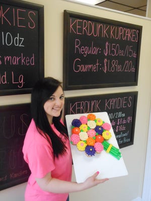 Kayla Jones, an employee at Kerdunk Kupcakery, holds a sample cupcake cake that will be part of a Mother's Day giveaway at the Perry Township business. (IndeOnline.com / Steven M. Grazier)