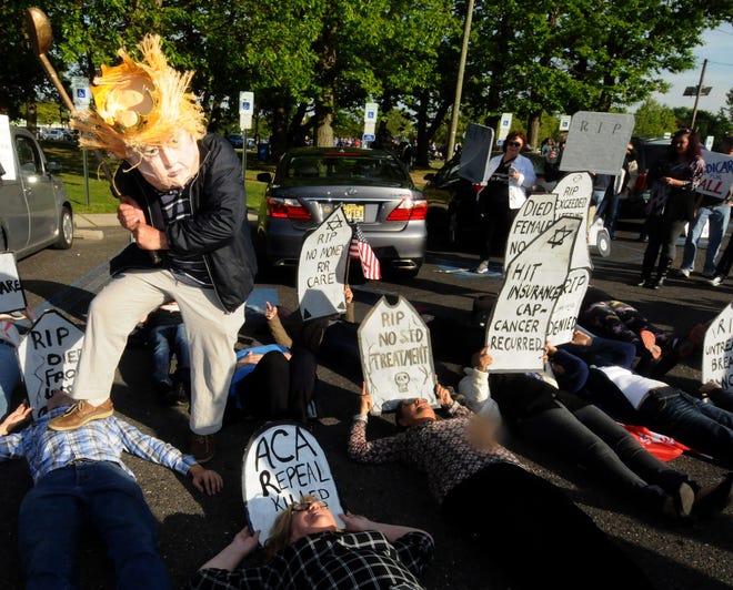 Elliot Crown, of New York City, impersonates President Donald Trump in the parking lot of the John F.Kennedy Center in Willingboro during a "die- in" outside a town hall with Congressman Tom MacArthur on Wednesday, May 10, 2017.