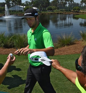First time player Jon Rahm signs autographs as he walks from the practice range. (Bob Mack/Florida Times-Union)