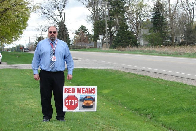 Portland Public Schools Transportation Director Gary Bond stands next to one of the new signs that serves as a gentle reminder to local drivers to be alert and cautious when school buses and children are present.