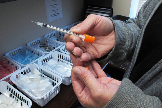 In this March 24, 2016 photo, a nurse for eastern Indiana’s Fayette County holds one of the syringes provided to intravenous drug users taking part in the county’s state-approved needle exchange program at the county courthouse in Connersville, Ind. The effort is in response to a hepatitis C outbreak among IV drug users. In a report released by the Centers for Disease Control and Prevention on Thursday, May 11, 2017, hepatitis C infections have nearly tripled since 2010 — an increase mainly due to the heroin epidemic. (AP Photo/Rick Callahan)