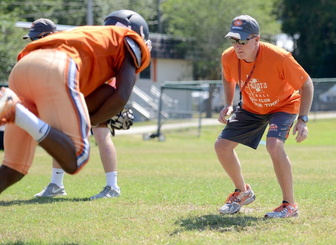 Coach Chris Stephenson goes over ball handling drills with his team during football practice at Mount Dora High School on Wednesday. [AMBER RICCINTO / DAILY COMMERCIAL]