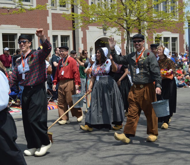 People dressed in Dutch costmes wave while walking in the Volksparade on Eight Street in Holland on May 10. The parade began at 2 p.m. and followed Eight Street from Columbia Avenue to Kollen Park. [Jake Allen/Sentinel]