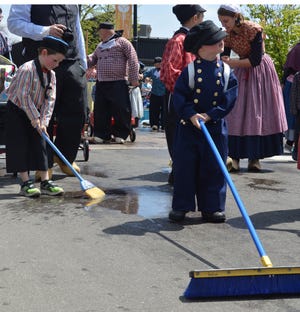 Two boys dressed in Dutch Costume sweep Eight Street before the Volksparade on May 10, 2017 in Holland. Street sweeping began at 1:15 p.m. and the parade at 2 p.m. Both were a part of the 2017 Tulip Time festival. [Jake Allen/Sentinel]