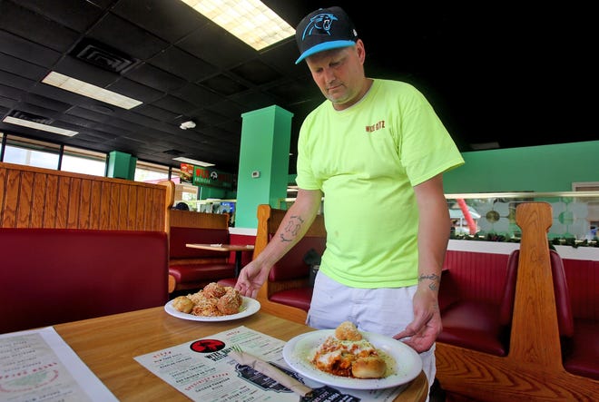 Owner Keith Tagner delivers spaghetti with meatballs and lasagna to a table at Wize Guys. [Brittany Randolph/The Star]