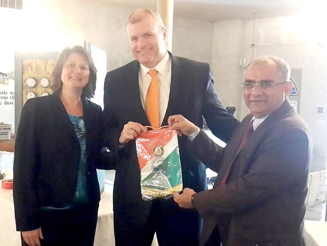 Sanjay Mehta, from Ahmedarad, India presented an International Rotary India flag to During Anderson, Rotary president. They are pictured with Rachel Doty, president elect. 

[COURTESY PHOTO]