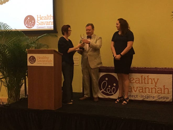 Teri Schell of the Forsyth Farmers’ Market makes the Health Innovation Award presentation to John Bennett and Caila Brown of the Savannah Bicycle Campaign at the Healthy Savannah 10th annual meeting.