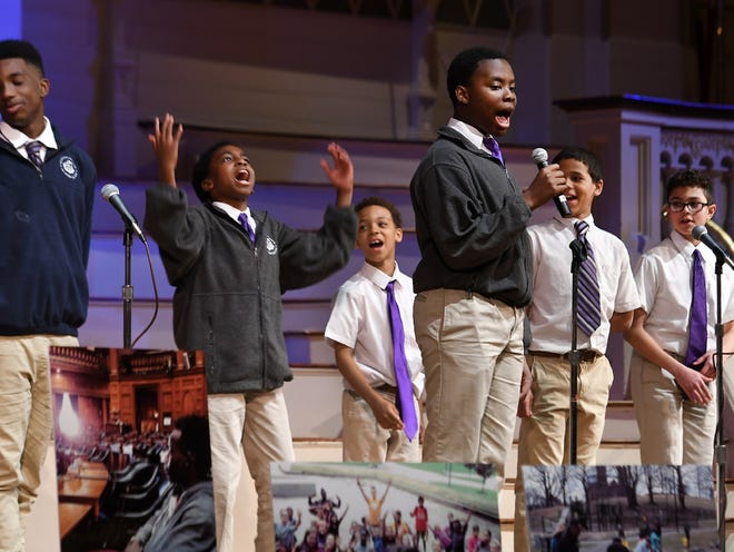 Darell Kwateng, 13, lead singer with Sharp Notes of the Nativity School, performs during the United Way's annual celebration on May 3 at Mechanics Hall. Rusty Lee Agyemang, second from left, is inspired by the singing. [T&G Staff/Christine Peterson]