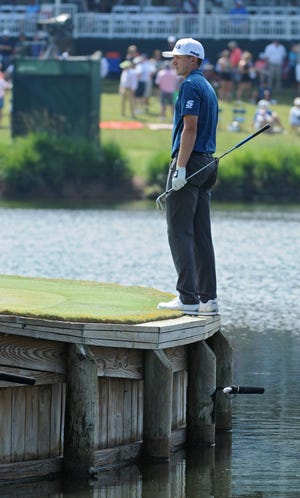 Mackenzie Hughes watches his chip from the edge of the 17th green balancing on the bulkhead above the water during the Second Round of The Players Championship at TPC Sawgrass Players Stadium Course in Ponte Vedra Beach, FL on Friday, May 12, 2017. (Terry Dickson/Florida Times-Union)