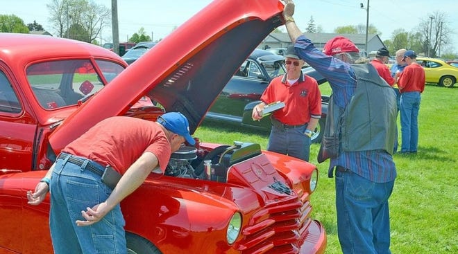Visitors to last year’s show look under the hood of one of the classic cars. The cruise-in will be Saturday and Sunday at the Branch County Fairgrounds.       [FILE PHOTO]