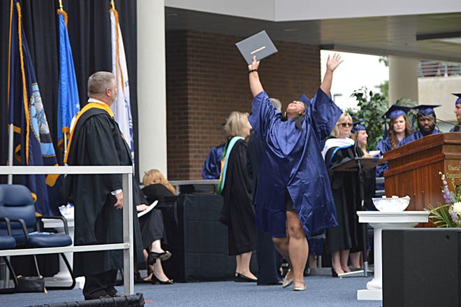 Channing Marshall celebrates graduating from the first culinary arts program to be held at Coastal Carolina Community College. [Alan Lane/The Daily News]