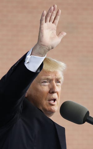 President Donald Trump waves to the crowd after delivering the commencement address Saturday at Liberty University in Lynchburg, Virginia. [STEVE HELBER/THE ASSOCIATED PRESS]