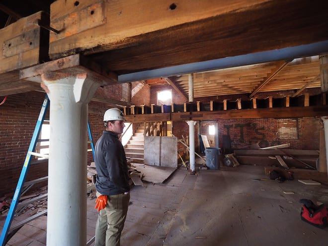 Mat Ouellette, assistant project manager for Chinburg Properties, shows an orginal low ceiling area that still remains, before a new level is built, at the Frank Jones Brew Yard in Portsmouth. [Rich Beauchesne/Seacoastonline]
