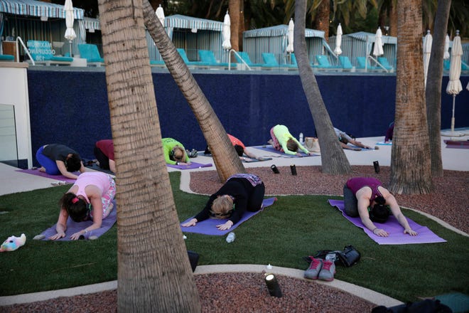 People take part in a yoga class by the pool at the Green Valley Ranch hotel and casino in Las Vegas. As Vegas continues to broaden the range of interests and wallets it appeals to, companies have been carefully selecting unique, picture-perfect sites where visitors and locals can practice yoga. (AP Photo/John Locher)
