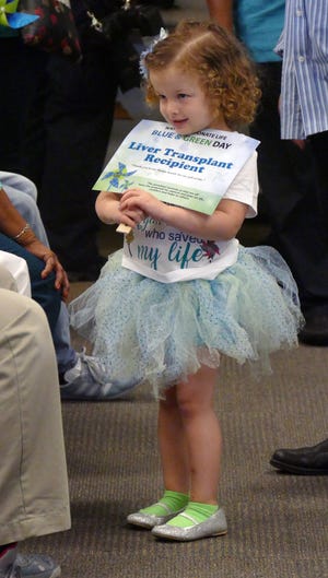 At 8 months old, Deanna Lynn Anderson was dying from a blocked liver duct but was saved by an organ donation from Kenneth Romero, 23. On Friday, April 21, 2017, Deanna, 3, holds a sign designating her as a liver transplant receipient. (Emily Michot/Miami Herald/TNS)